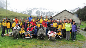 Gruppenbild einer Wandergruppe mit Trekking-Rollstühlen in den Bergen